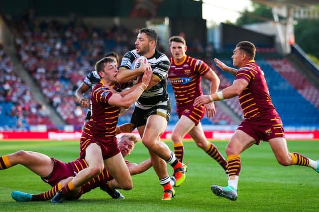 Stopped in his tracks: Hull FC's Jake Connor is tackled by Huddersfield's Jake Wardle and Aaron Murphy.