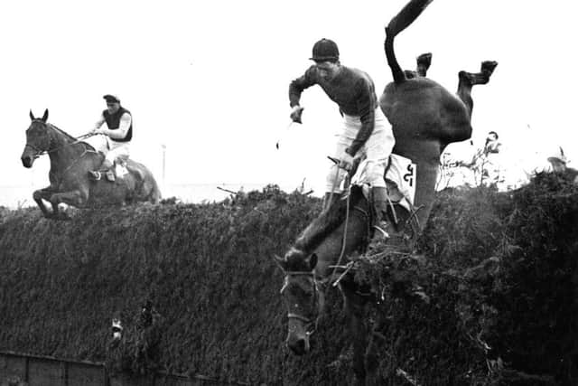 Michael Scudamore and Oxo clear's Becher's Brook in the 1959 Grand National as Sirprise Packet, ridden by his great friend Gerry Scott from Middleham, crashes out.