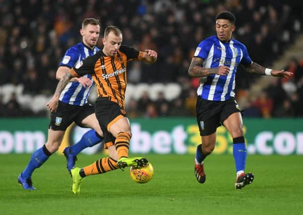 Hull's Kamil Grosicki takes on Sheffield Wednesday's Tom Lees and Liam Palmer.