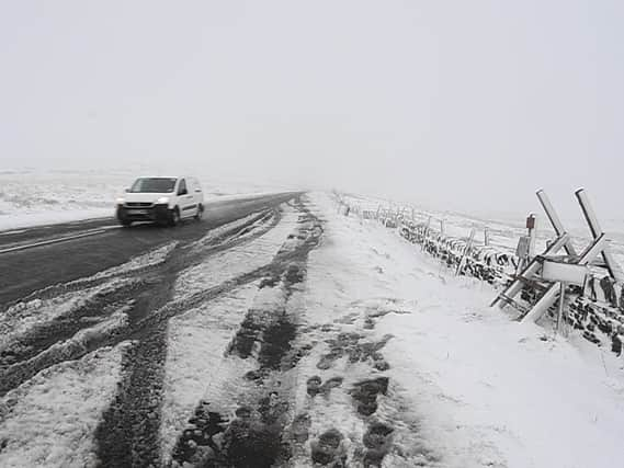 A van drives past snowy fields above Holmfirth