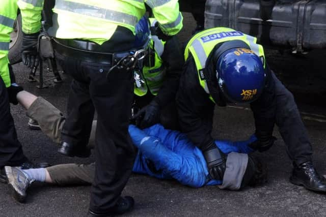 Police restrain a tree protester on Kenwood Road who had hidden under a contractor's cherry picker vehicle for several hours in an attempt to stop work.