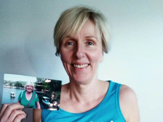 Sarah McAndrew holding a photograph of her mother Jean.