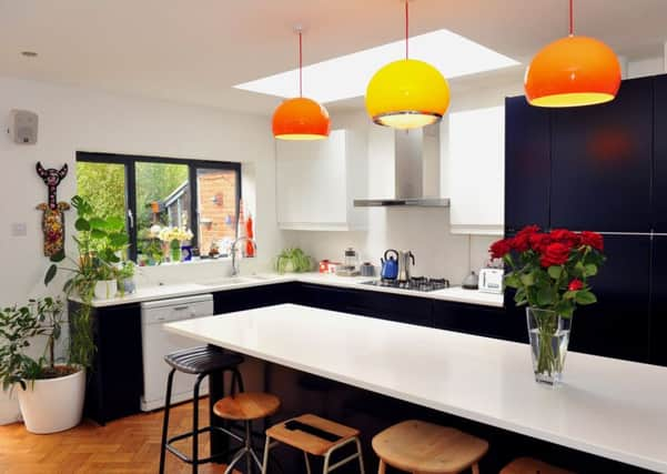 The kitchen area with vintage lights from Etsy and a collection of vintage stools surrounding the island.