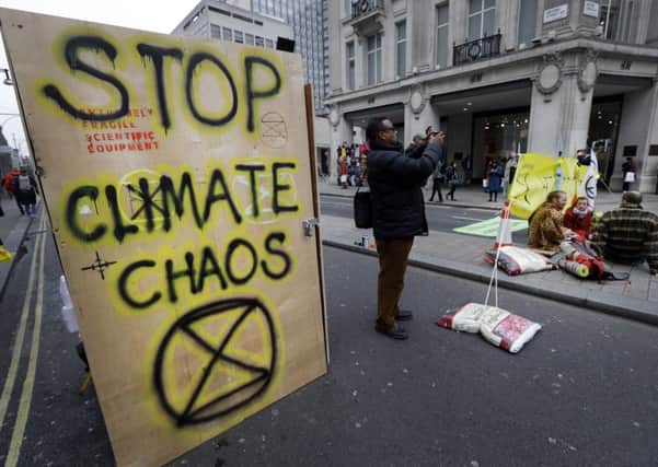 Writing on the side of a temporary toilet set up as the road is blocked during a climate protest at Oxford Circus in London, Tuesday, April 16, 2019. The group Extinction Rebellion is organizing a week of civil disobedience against what it says is the failure to tackle the causes of climate change. (AP Photo/Kirsty Wigglesworth)