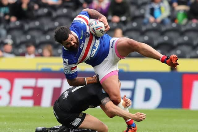 Dean Hadley of Hull FC tackles David Fifita of Wakefield Trinity.