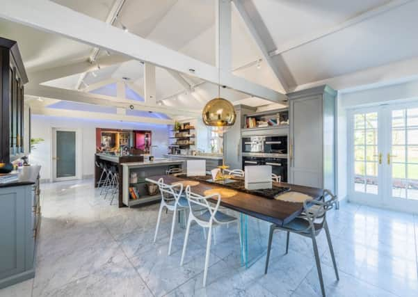 The dining kitchen with cabinets by Stephen Neall. The island has a leather- topped bar and ice trough.