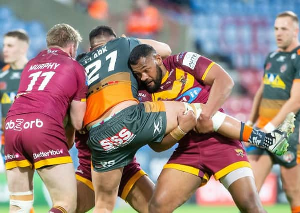 Castleford's Mitch Clark is tackled by Huddersfield's Ukuma Ta'ai. Picture: Allan McKenzie/SWpix.com