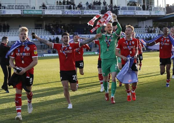 Barnsley players celebrate promotion after the Sky Bet League One match against Bristol Rovers.