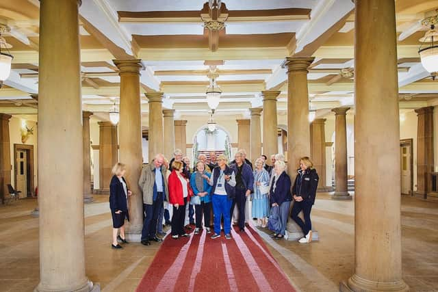 Sue Gravil leading a tour in the pillared hall, where she arrived as a student in 1967