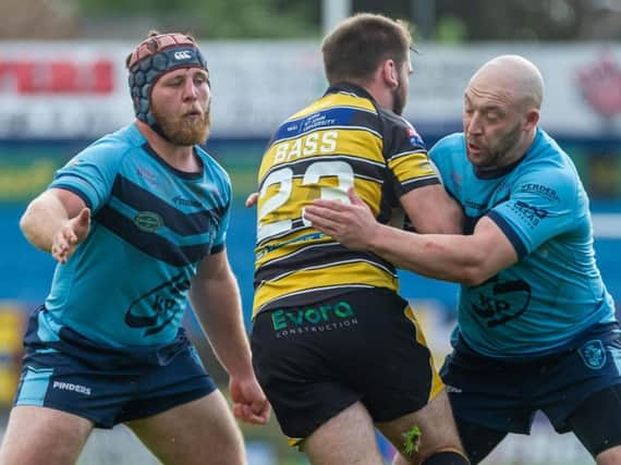 Luke Cooper and John Davies aim to stop Jason Bass in Featherstone Rovers' game at York. Picture: James Heaton