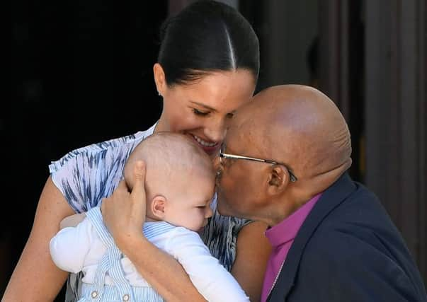 Baby Archie is kissed on the forehead by Archbishop Desmond Tutu while in the hands of his mother The Duchess of Sussex in cape Town, on day three of their tour of Africa.