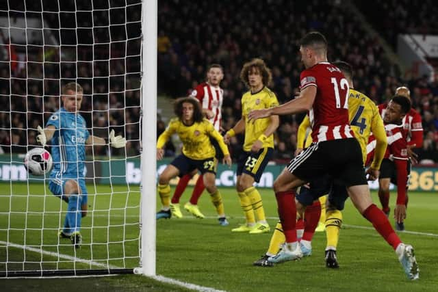 Lys Mousett of Sheffield Utd (partially hidden) scores against Arsenal.