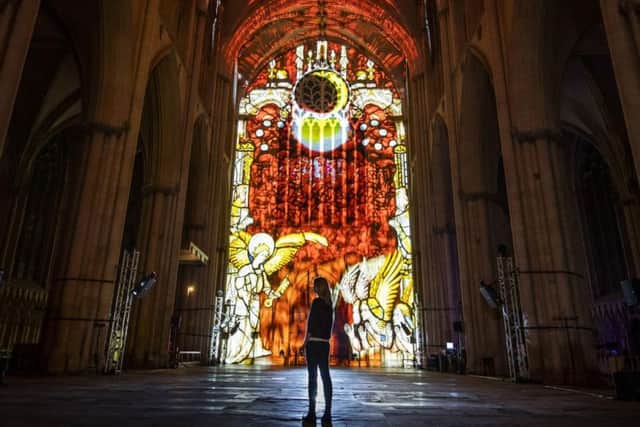 A woman looks on as an art installation is projected on to the interior of York Minster ahead of their Northern Lights opening. 
PA Photo.