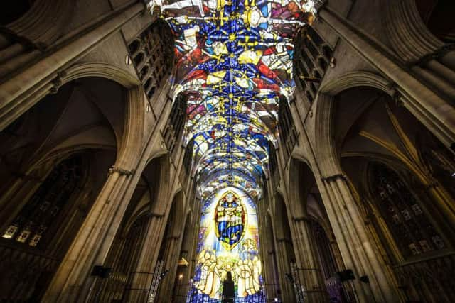 A woman looks on as an art installation is projected on to the interior of York Minster ahead of their Northern Lights opening.
 PA Photo.