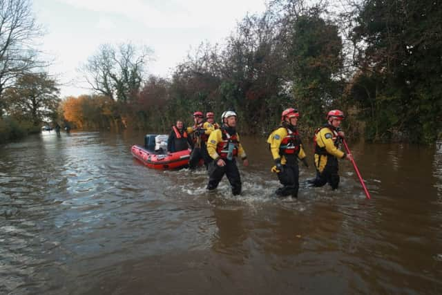 Rescuers pull a boat through floodwater in Fishlake, Doncaster.