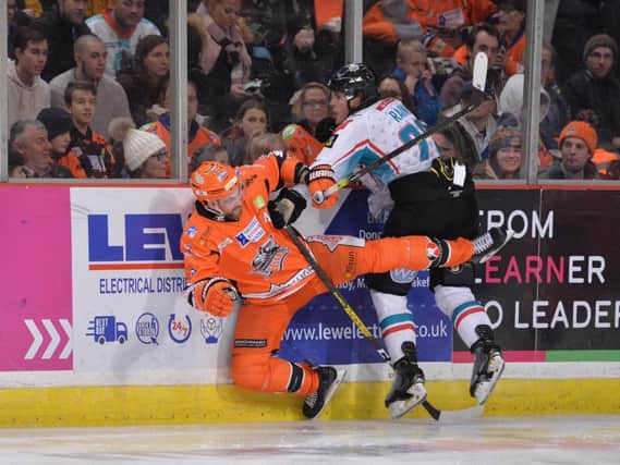 TAKING A TUMBLE: Sheffield Steelers' two-goal hero John Armstrong collides on the boards with Belfast's Kevin Raine. Picture courtesy of Dean Woolley.