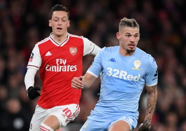 Leeds United's Kalvin Phillips makes a break past Mesut Ozil of Arsenal. (Photo by Shaun Botterill/Getty Images)