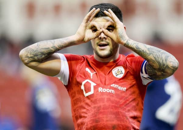 Barnsley captain Alex Mowatt celebrates after slotting home the opening goal at Oakwell against Huddersfield (Picture: Dean Atkins)