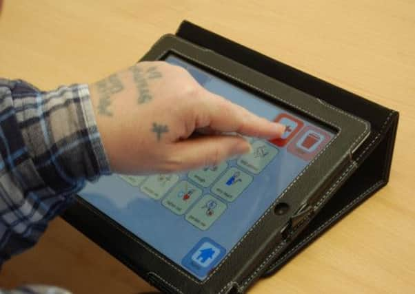 Kevin Beverley using an iPad at the Carlton daycare centre in Barnsley. The 55 year old who was left paralysed and brain damaged in a brutal attack today said it was "great" to be able to communicate for the first time in 20 years. PRESS ASSOCIATION Photo.