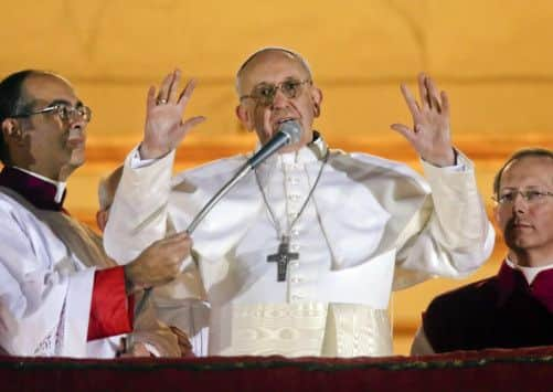 Pope Francis looks at the crowd from the central balcony of St. Peter's Basilica at the Vatican