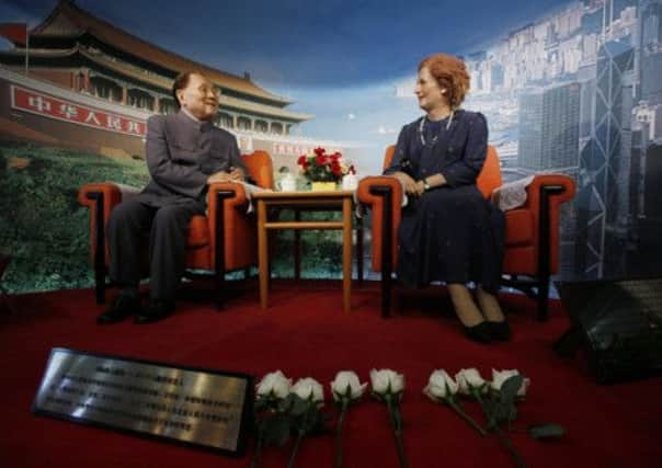 Flowers are laid by staff members in front of the wax statue of former British Prime Minister Margaret Thatcher.