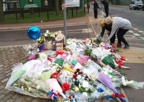 Two women lay flowers outside the Royal Artillery Barracks in Woolwich