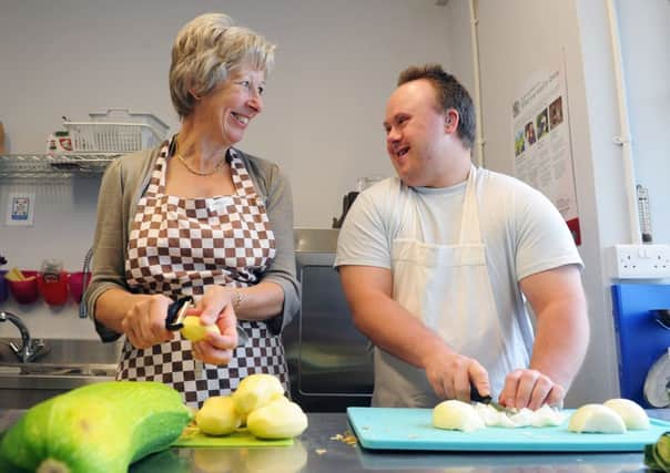 Chris Redhead and Simon Waggett preparing vegetables and cafe staff, below.