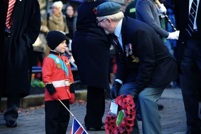 Four-year-old Finlay Monteith chats to vetern Dennis Marshall before the start of the Remembrance Day Service parade through Morley, Leeds.