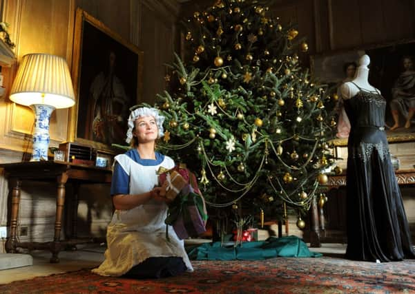 Mollie Dodd, General Manager of Nunnington Hall, dressed as a maid by the tree in the Oak Hall