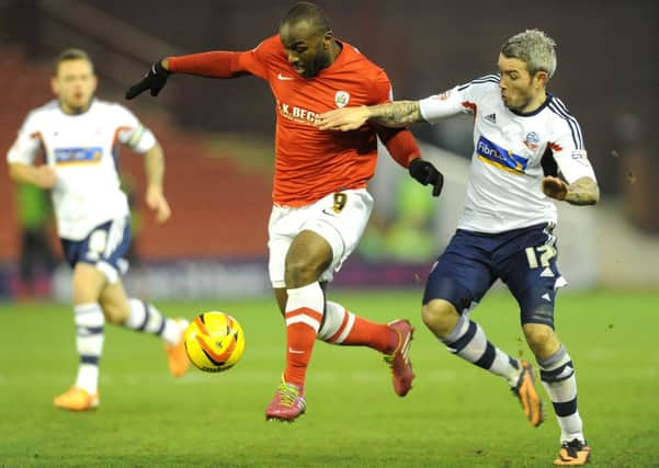 Barnsley's Jason Scotland holds off Bolton's Kevin McNaughton.
 (Picture: James Hardisty).