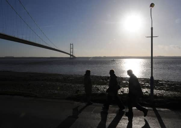 People take a walk in the winter sunshine near the Humber Bridge