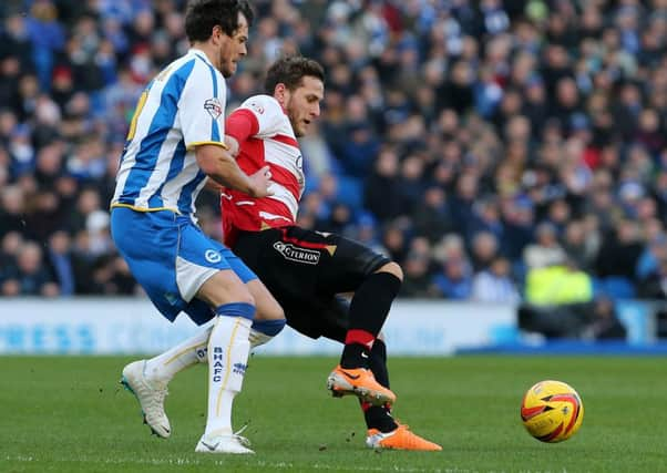 Brighton's Gordon Greer (left) challenges Doncaster Rovers's Billy Sharp