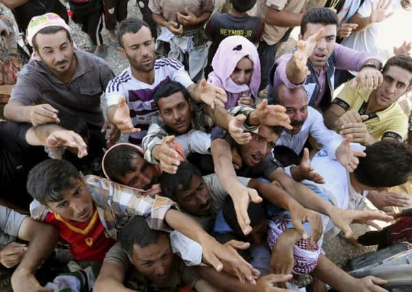 Displaced Iraqis from the Yazidi community gather for humanitarian aid at the Syria-Iraq border at Feeshkhabour border point, northern Iraq.