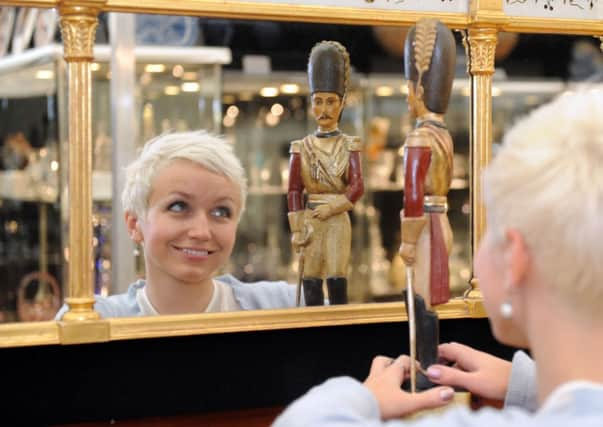 Harriet Packford  with a naive wood carving of a  French Cavalry Soldier