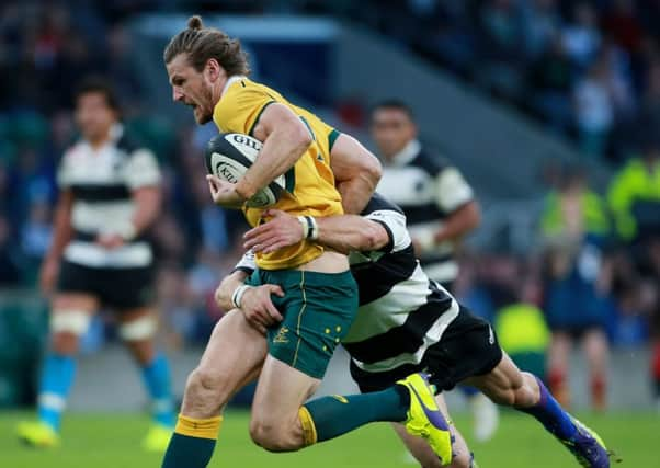 Australia's Nick Cummins is tackled by Barbarians Sarel Pretorius during the Killik Cup match at Twickenham, London.