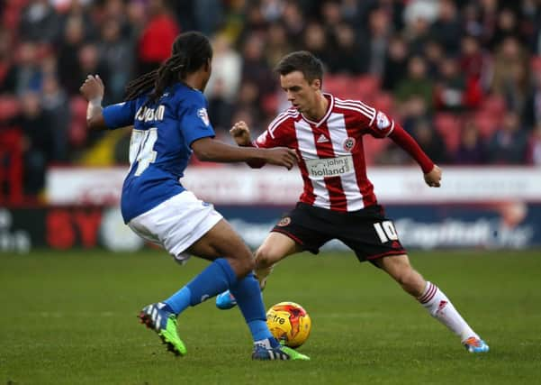 STALEMATE: Sheffield Uniteds Stefan Scougall comes up against the impressive Daniel Johnson, the Oldham midfielder on loan from Aston Villa, at Bramall Lane on Saturday. Picture: Martyn Harrison