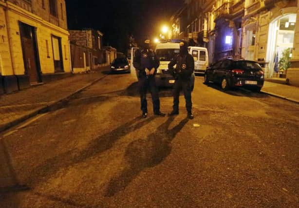 Police stand guard around the central police headquarters in Brussels