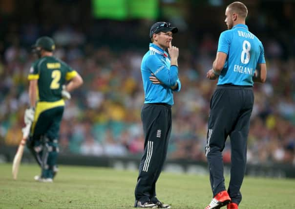 England's captain Eoin Morgan, center, talks with his bowler Stuart Broad during their One Day International cricket match against Australia in Sydney. (AP Photo/Rick Rycroft)