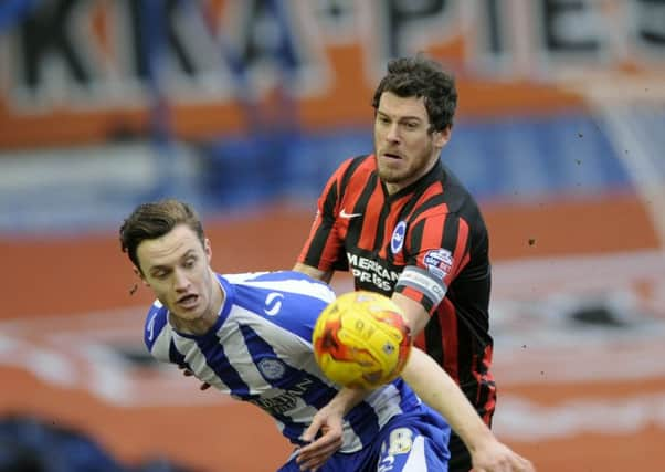 Owls' Will Keane holds off Brighton's Greer.