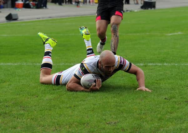 Bulls' Adrian Purtell slides over for the second of his tries. (Picture: Tony Johnson)