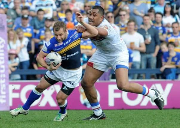 Rob Burrow is tackled by Ali Lauitiiti.