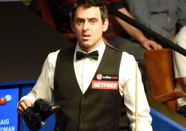 Ronnie O'Sullivan talks with referee Brendan Moore about his shoes his after he played in his socks against Craig Steadman, during the Betfred World Championships at the Crucible Theatre, Sheffield.