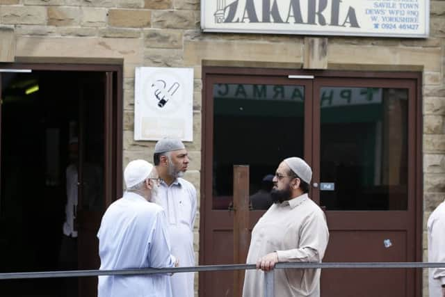 Men outside the Masjid E Zakaria Mosque, in Dewsbury, where Talha Asmal, Britain's youngest suicide bomber attended