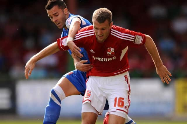 Swindon Town's Andy Williams (right) and Leyton Orient's Leon McSweeney