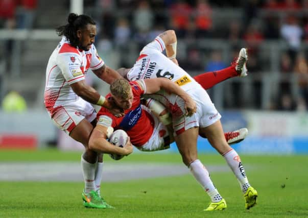 Hull KRs Graeme Horne is tackled by Atelea Vea and Travis Burns, of St Helens, during his sides 52-12 Super League defeat last night (Picture: Steve Riding).