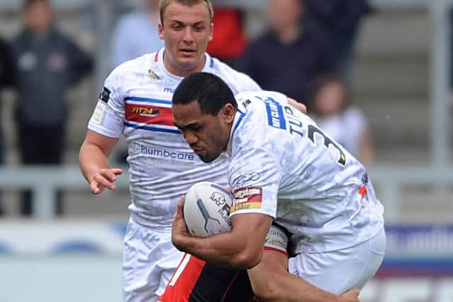 Wildcats' Bill Tupou is brought to ground by the Salford defence