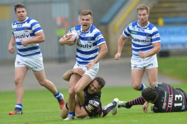 Halifax's Ben Johnston is tackled by Widnes Vikings' Lloyd White. Picture: Anna Gowthorpe