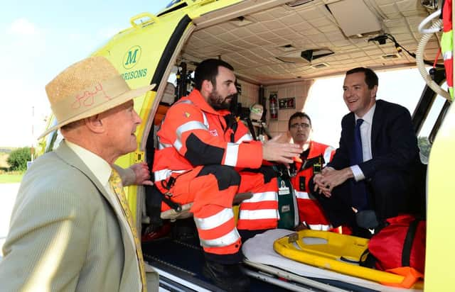 25 Aug 2015...Chancellor George Osborne chats with Geoffrey Boycott and paramedics during a visit to the Yorkshire Air Ambulance facility at Nostell Priory near Wakefield. Picture Scott Merrylees SM1009/26c