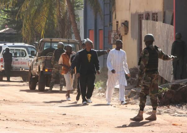 Security force personnel escort people fleeing from the Radisson Blu Hotel in Bamako, Mali