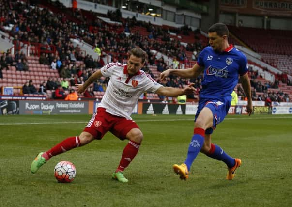 United's Billy Sharp tussles with James Wilson of Oldham Athletic.